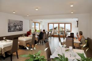 a dining room with people sitting at tables at Hotel Garni Paler in Tirolo