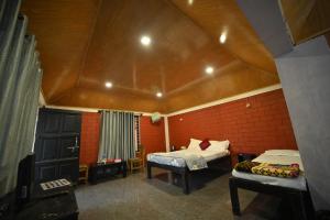 a bedroom with two beds and a roof at Coorg HomeStay Resort in Kushālnagar