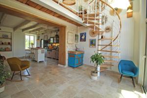 a living room with a spiral staircase and a kitchen at La cle des champs 