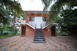 dom ze schodami prowadzącymi do niego w obiekcie Coorg HomeStay Resort w mieście Kushalanagar