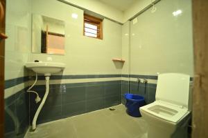 a bathroom with a toilet and a sink at Coorg HomeStay Resort in Kushālnagar