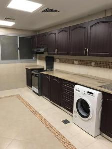 a kitchen with a washer and dryer in it at SN Realestate Resedent in Abu Dhabi