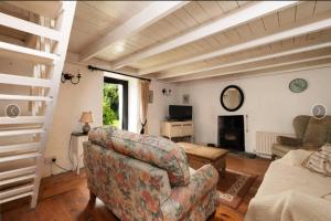 a living room with a couch and a chair at Remarkable 3-Bed Cottage in Ahakista durrus in Ahakista