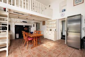 a kitchen with a wooden table and a refrigerator at Remarkable 3-Bed Cottage in Ahakista durrus in Ahakista