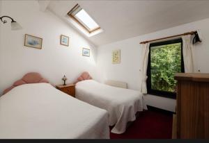 a bedroom with two beds and a window at Remarkable 3-Bed Cottage in Ahakista durrus in Ahakista