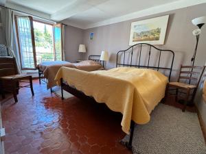 ein Schlafzimmer mit 2 Betten mit gelber Bettwäsche in der Unterkunft Luberon maison de village entière 2 à 6 personnes in Cabrières-dʼAigues