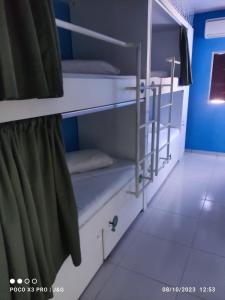 a room with white bunk beds in a room at GVR Praia Hostel in João Pessoa