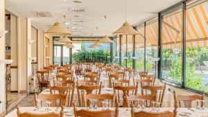 Bobby Executive في سانريمو: غرفة طعام مع طاولات وكراسي ونوافذ