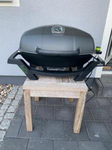 a toaster sitting on top of a wooden bench at Am Horizont No 3 Fewo für 4 Pers, 2 Schlafzimmer, W-LAN, Homeoffice geeignet, Garten, Strandkorb, BBQ- Grill, Parkplatz in Zingst