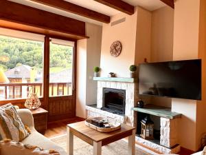 un soggiorno con camino e TV a schermo piatto di Sol de Espot a Espot