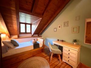 a bedroom with a bed and a desk in a attic at Sol de Espot in Espot