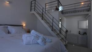 a bedroom with a bed with white towels and a staircase at Lemon Tree Houses in Áno Meriá