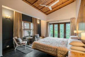 Casa Bhimtal في بهيمتال: غرفة نوم بسرير ونافذة كبيرة