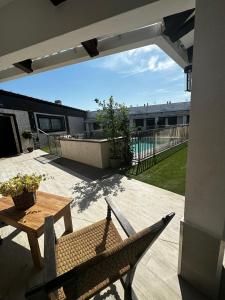 un patio con una mesa de madera, una silla, una mesa y un mantel en Hotel Rural Irina, en Badajoz