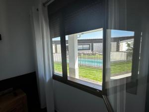 ventana en una habitación con vistas a la piscina en Hotel Rural Irina en Badajoz