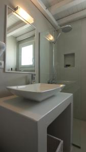 a bathroom with a white sink and a mirror at Lemon Tree Houses in Áno Meriá