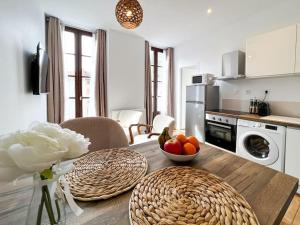 a kitchen with a table with a bowl of fruit on it at Hyper-centre de Grenoble, suite parentale - wifi fibre - cocon in Grenoble