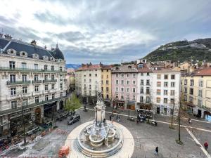 a city with a fountain in a plaza with buildings at Hyper-centre de Grenoble, suite parentale - wifi fibre - cocon in Grenoble