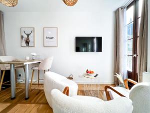 a white living room with a table and chairs at Hyper-centre de Grenoble, suite parentale - wifi fibre - cocon in Grenoble