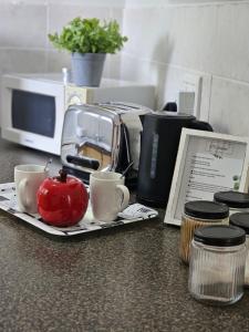 a counter with two cups and a toaster and an apple at @Galpin15 in Summerstrand