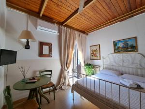 1 dormitorio con cama, mesa y TV en I Vespri en Catania