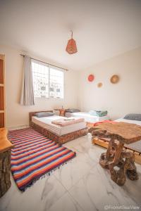 a bedroom with two beds and a rug on the floor at Easy Going in Imsouane