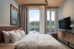 a bedroom with a large bed and a large window at Skaret by Vander in Tromsø