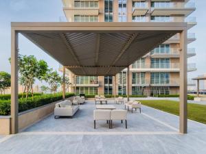un patio con sofás y mesas frente a un edificio en Emaar Beachfront 2bdr Apartment on Beach Isle, en Dubái