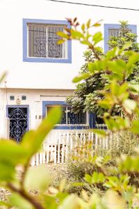 uma casa branca com portas azuis e uma cerca em Easy Going em Imsouane