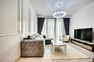 sala de estar con sofá y TV en Emaar Beachfront 2bdr Apartment on Beach Isle, en Dubái