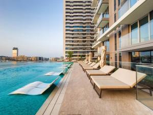 una fila de tumbonas junto a una piscina en Emaar Beachfront 2bdr Apartment on Beach Isle, en Dubái