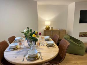 a wooden table with chairs and a dining room at Chelston Grange Torquay Near the Beach with Private Garden & Parking in Torquay