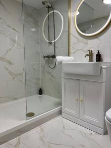 a bathroom with a shower and a sink and a tub at Chelston Grange Torquay Near the Beach with Private Garden & Parking in Torquay