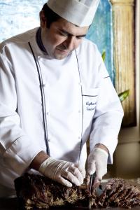 a chef cutting into a piece of meat at Hotel Aqua in Marmaris