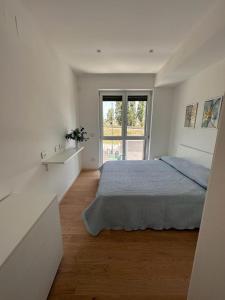 ein weißes Schlafzimmer mit einem Bett und einem Fenster in der Unterkunft Panama Room Arechi in Salerno