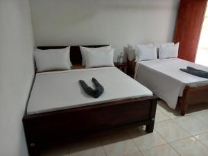 two beds with shoes on them in a room at LLT Tourist Inn and Safari Jeep in Wilpattu