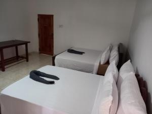 1 dormitorio con 2 camas y mesa en LLT Tourist Inn and Safari Jeep en Wilpattu