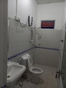 baño con aseo y teléfono en la pared en LLT Tourist Inn and Safari Jeep en Wilpattu