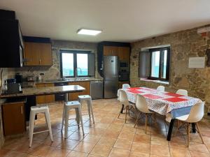 una cucina con un tavolo e sedie in una stanza di Casa O Corvo, chalet cerca de Vigo en plena naturaleza a Vilacoba