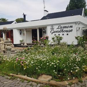 Biały budynek z kwiatami przed nim w obiekcie Lamon Guesthouse w mieście Kroonstad