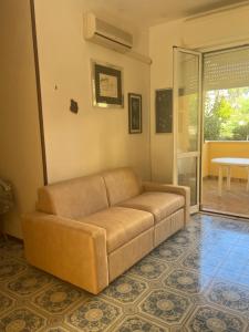 a brown couch sitting in a living room at Da Ike residence con piscina in Santa Marinella