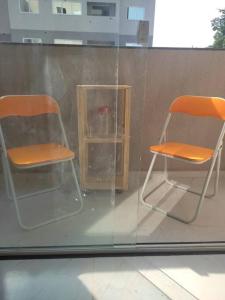 2 chaises assises à l'intérieur d'une fenêtre en verre dans l'établissement Novo ap. João Pessoa!, à João Pessoa