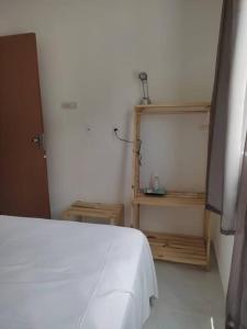 - une chambre avec un lit blanc et une étagère en bois dans l'établissement Novo ap. João Pessoa!, à João Pessoa