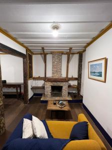 a living room with a yellow couch and a fireplace at History Hostel in Ouro Preto