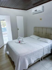 a bedroom with a white bed with a towel on it at POUSADA AREIA DA PRAIA in Fortaleza