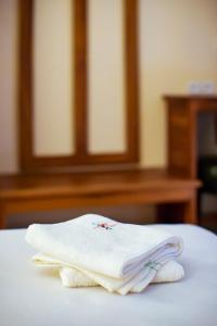 a stack of towels sitting on top of a bed at Anjary Hotel Antananarivo in Antananarivo