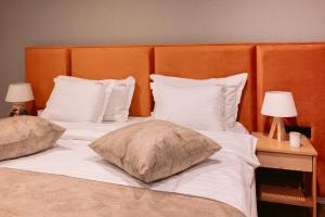a bedroom with two beds with white pillows and two lamps at La Boheme Corbeanca - partener Therme in Ostratu