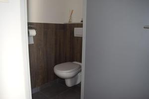 ein Badezimmer mit einem weißen WC und Holzwänden in der Unterkunft Gîte le Grenier in Murviel