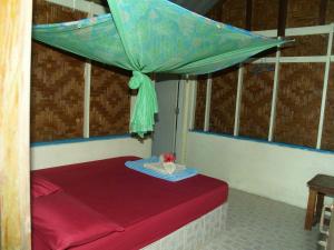 Cama en habitación con dosel azul en Littleduck bungalow Koh Chang Ranong, en Koh Chang