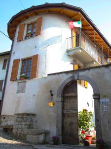 an old building with an archway and a balcony at B&B Contrada Lunga in Abbadia Lariana